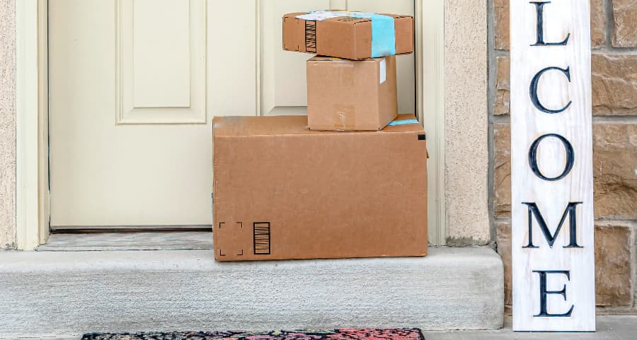 Packages on the doorstep of a home with a welcome sign in St. Louis